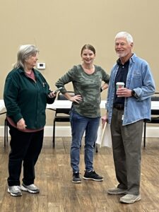 People attending a veterans event, holding coffee and talking