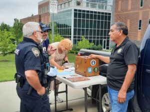 Founder of Gulf War Veteran standing by a table with a police officer and two other people